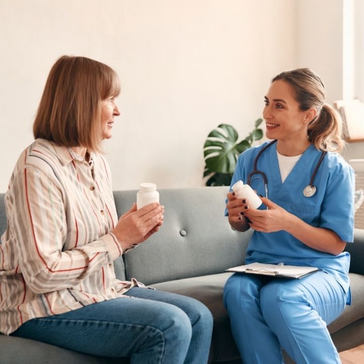 Nurse practitioner discussing medication options with patient seated on couch.