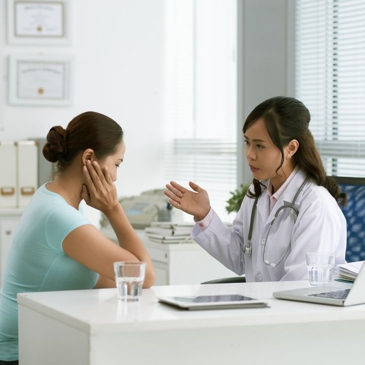 Psychiatrist consulting with a patient experiencing emotional distress during an office appointment.